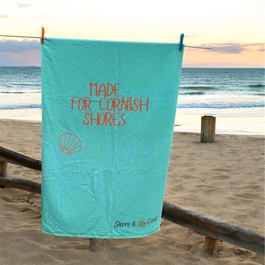 alt=“Mint green microfibre beach towel with the slogan ‘Made for Cornish Shores’ in bold white text – lightweight, quick-drying, and perfect for coastal adventures”